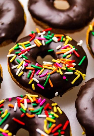 Colorful sprinkled chocolate donuts with vibrant toppings and glossy glaze.