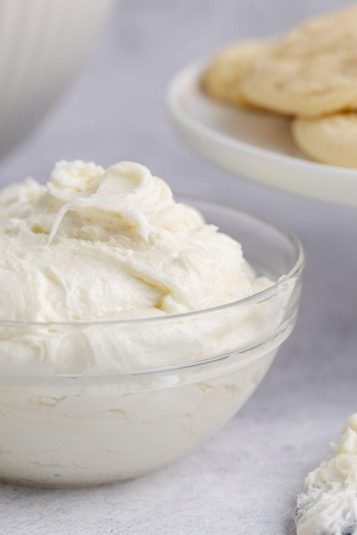 Creamy vanilla frosting in a glass bowl for baking and decorating desserts.