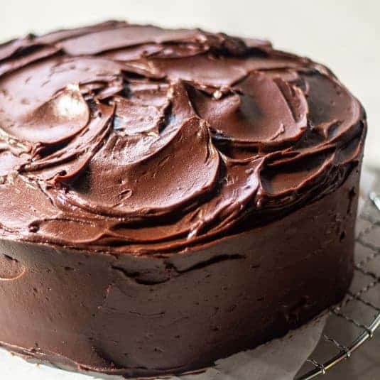 Rich chocolate cake with smooth frosting and decorative chocolate shavings.