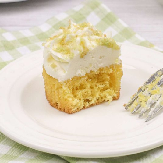 A slice of lemon cake on a plate with a fork.
