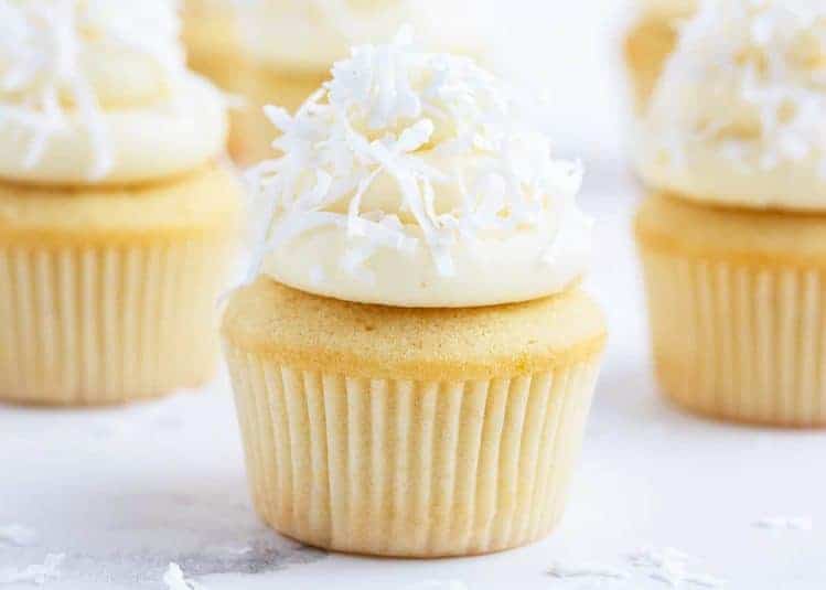 Bright Lemon Cupcake with White Candied Shredded Coconut, Vanilla frosting, and Coconut shavings.