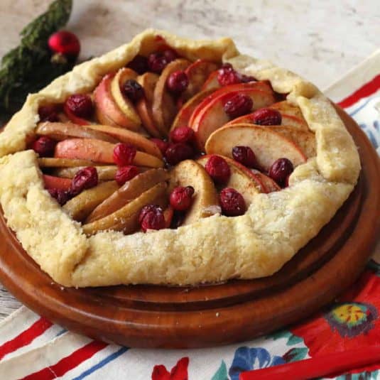 A slice of an Apple Scones on a white plate and a cup of tea.