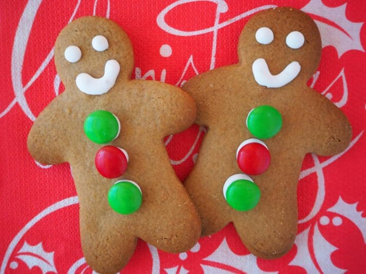Pair of decorated gingerbread med on a red Christmas serviette.