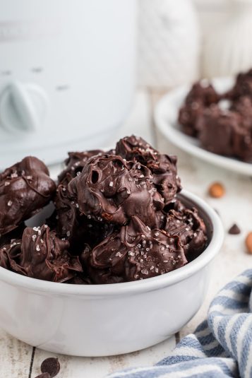 Close-up of slow cooker sea salt chocolate almond clusters in a white bowl.