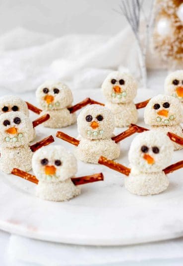 Multiple snowman truffles on a decorative dish.