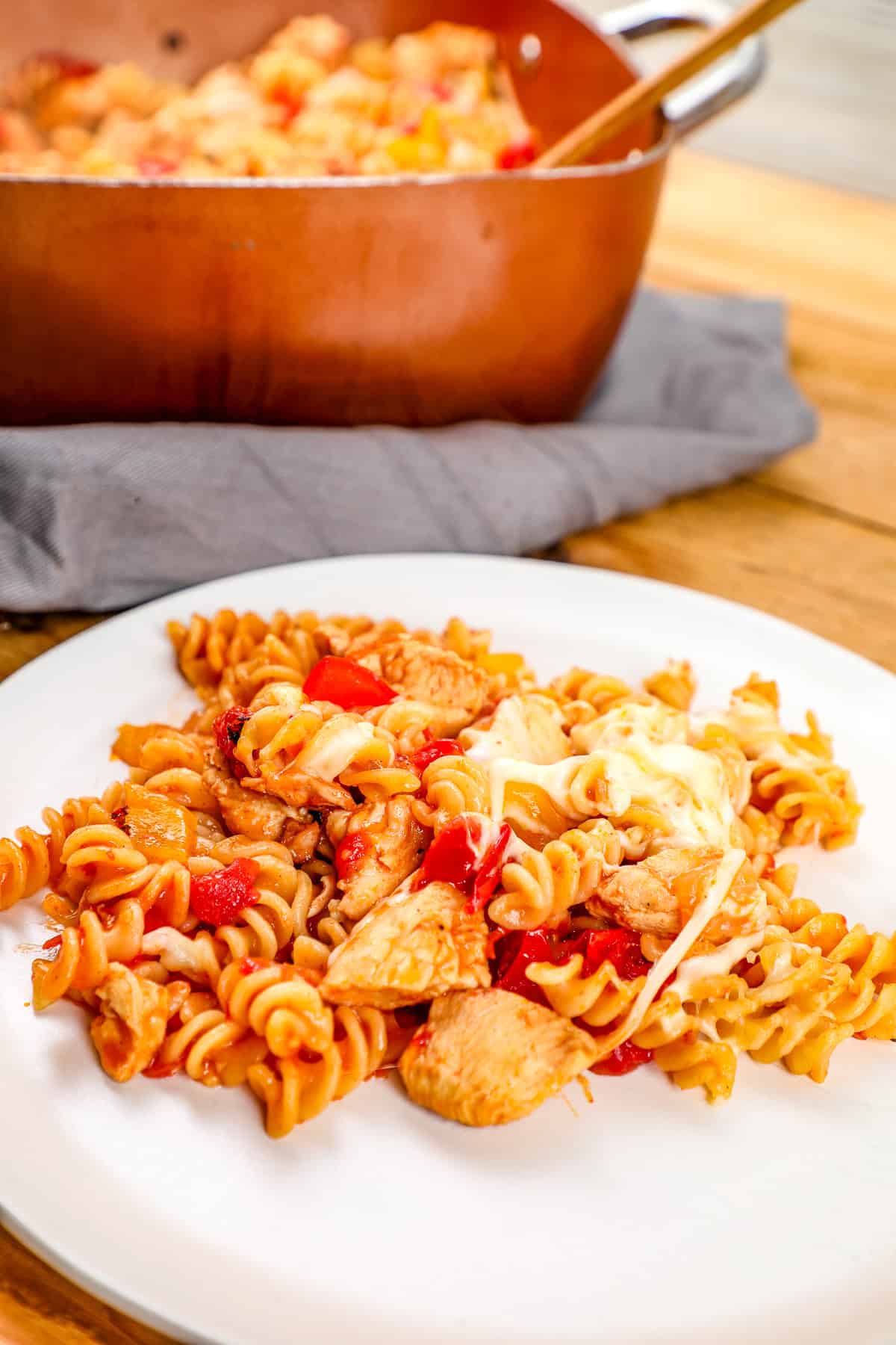 Savory baked chicken and vegetable pasta dish with rotini and cheese, served on a white plate.