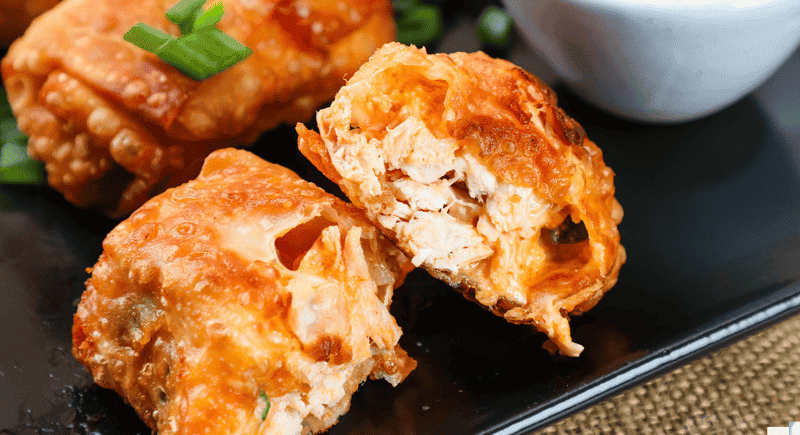 a closeup of a buffalo chicken egg roll cut in half.