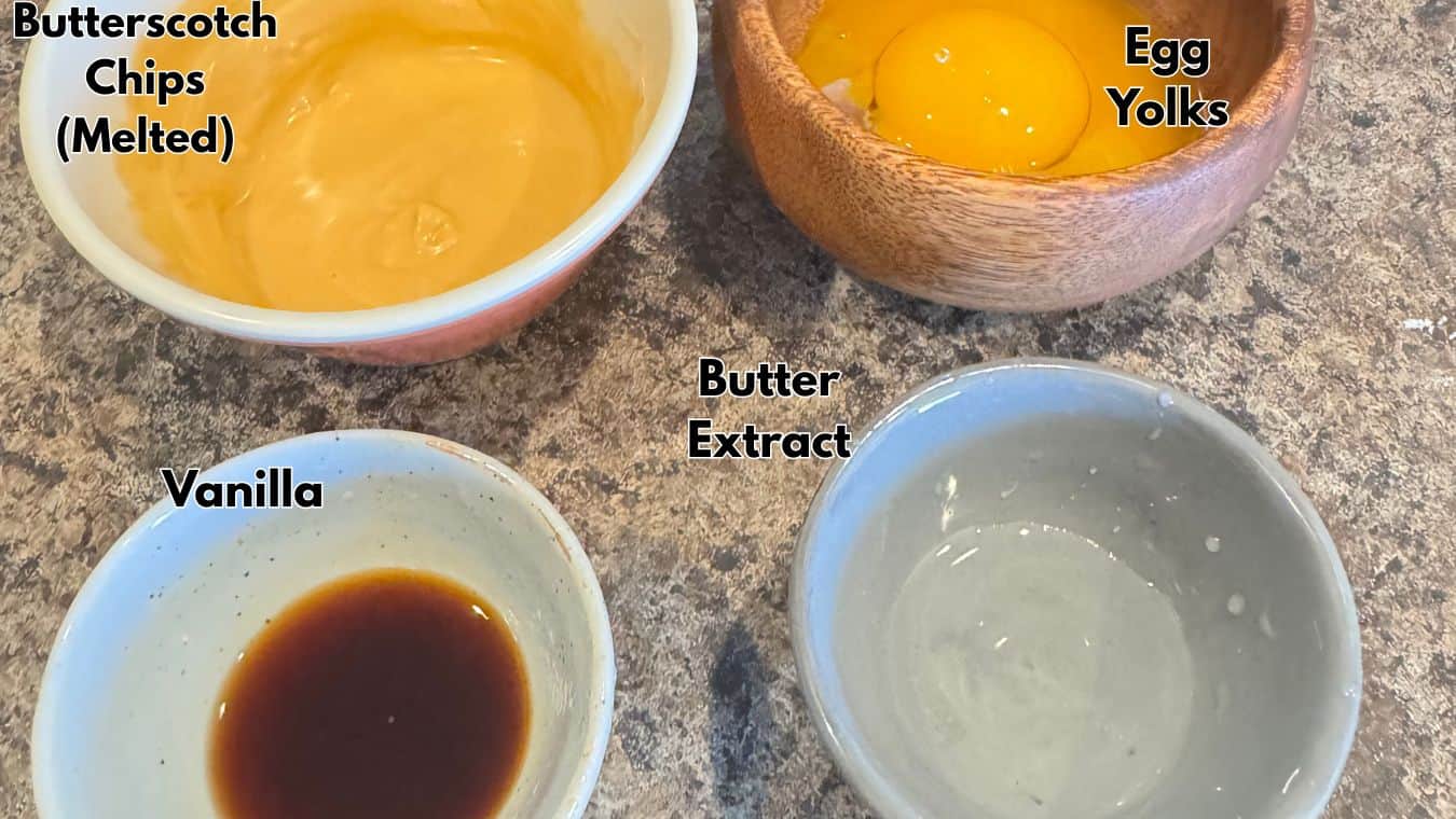 Butterscotch chips melted, egg yolks, vanilla, butter extract on a baking countertop for sweet recipes.