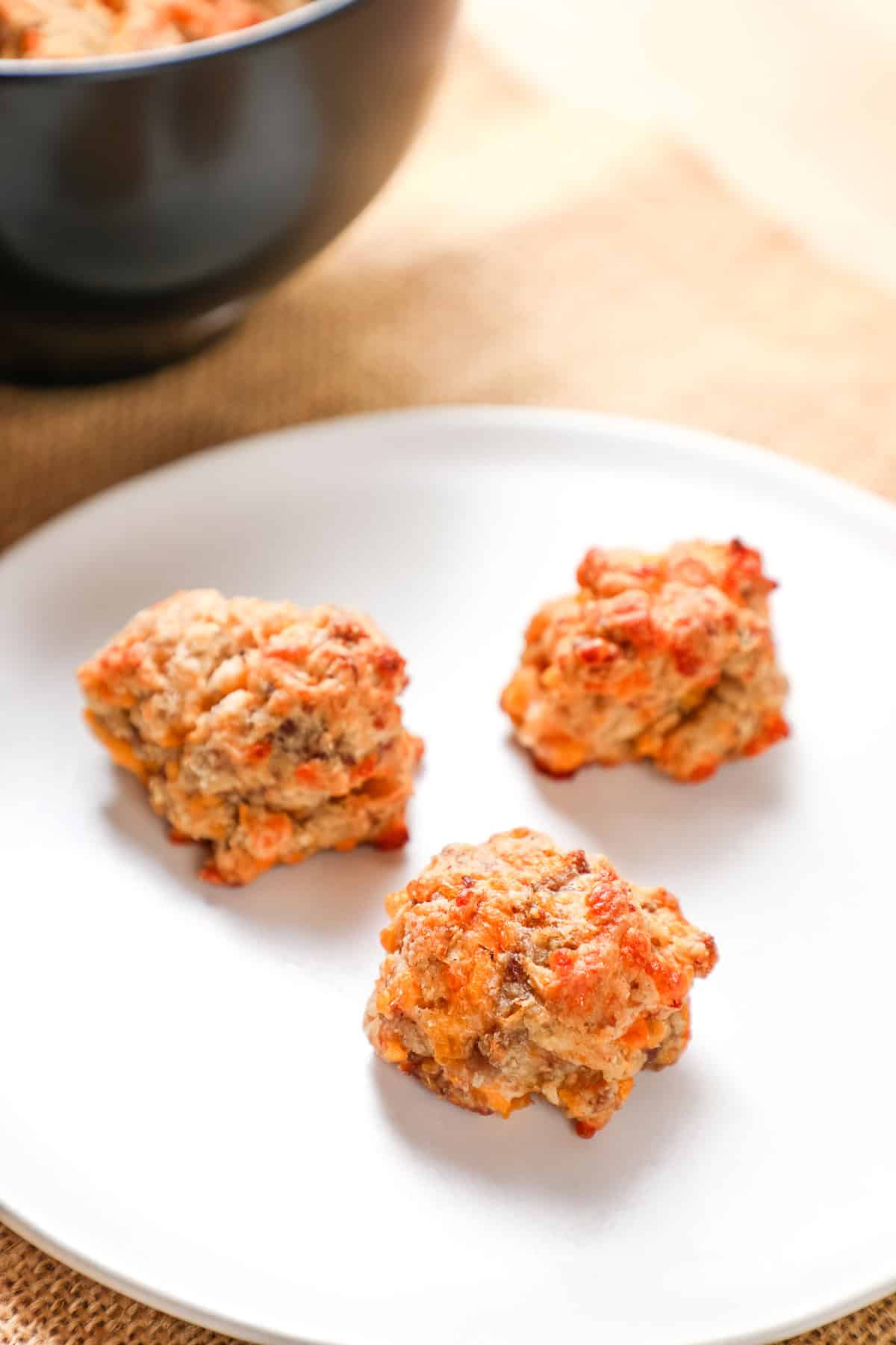 Savory meatballs with breadcrumbs, cheese, and herbs on a white plate, ready to serve.