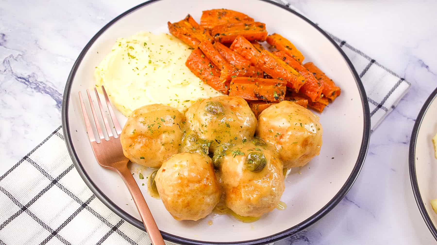 chicken meatballs in a lemon butter caper sauce served with mashed potatoes and carrots.