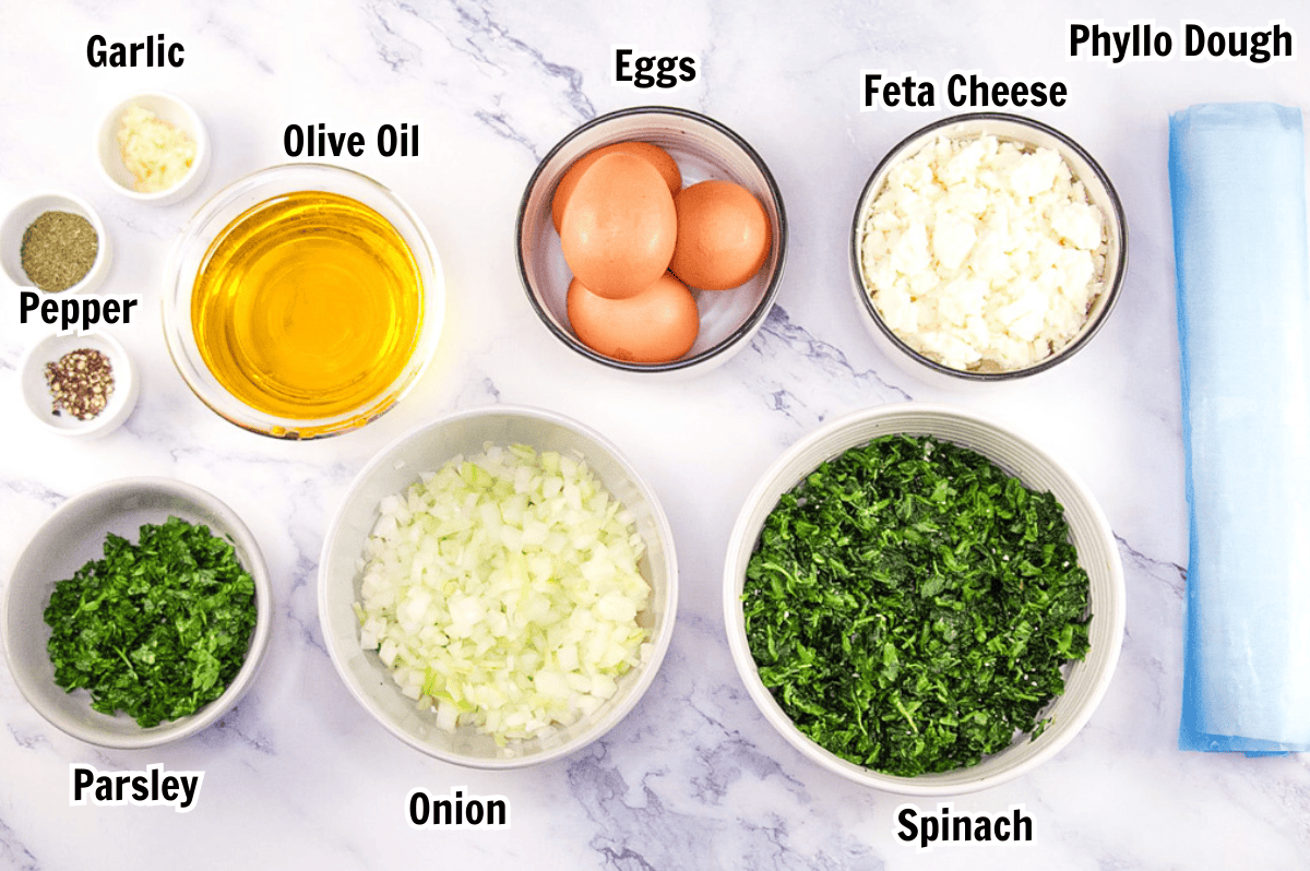 ingredients including garlic, olive oil, eggs, phyllo dough, feta cheese, onion, spinach, and parsley. 
