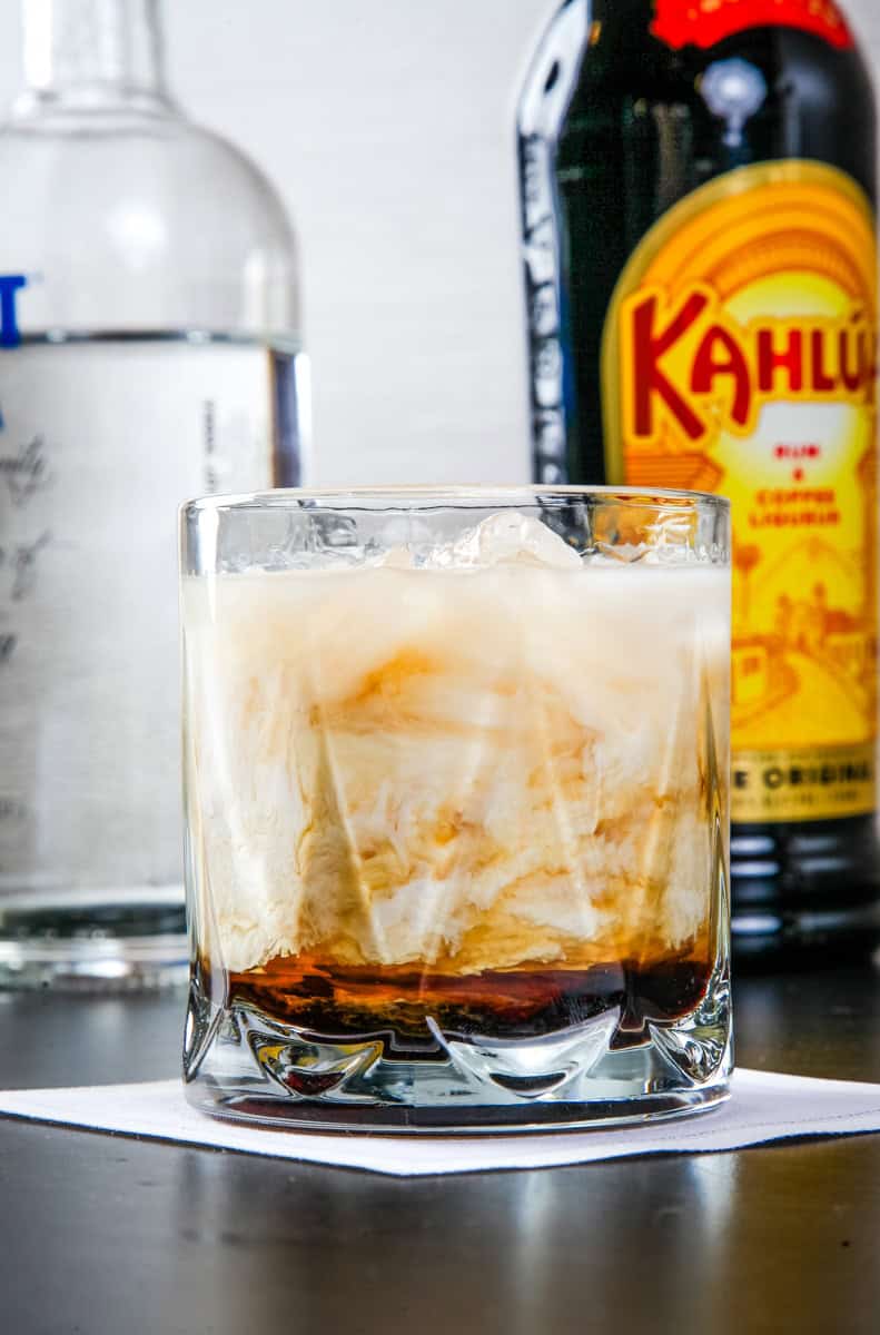 a white Russian cocktail with heavy cream in a rocks glass. 