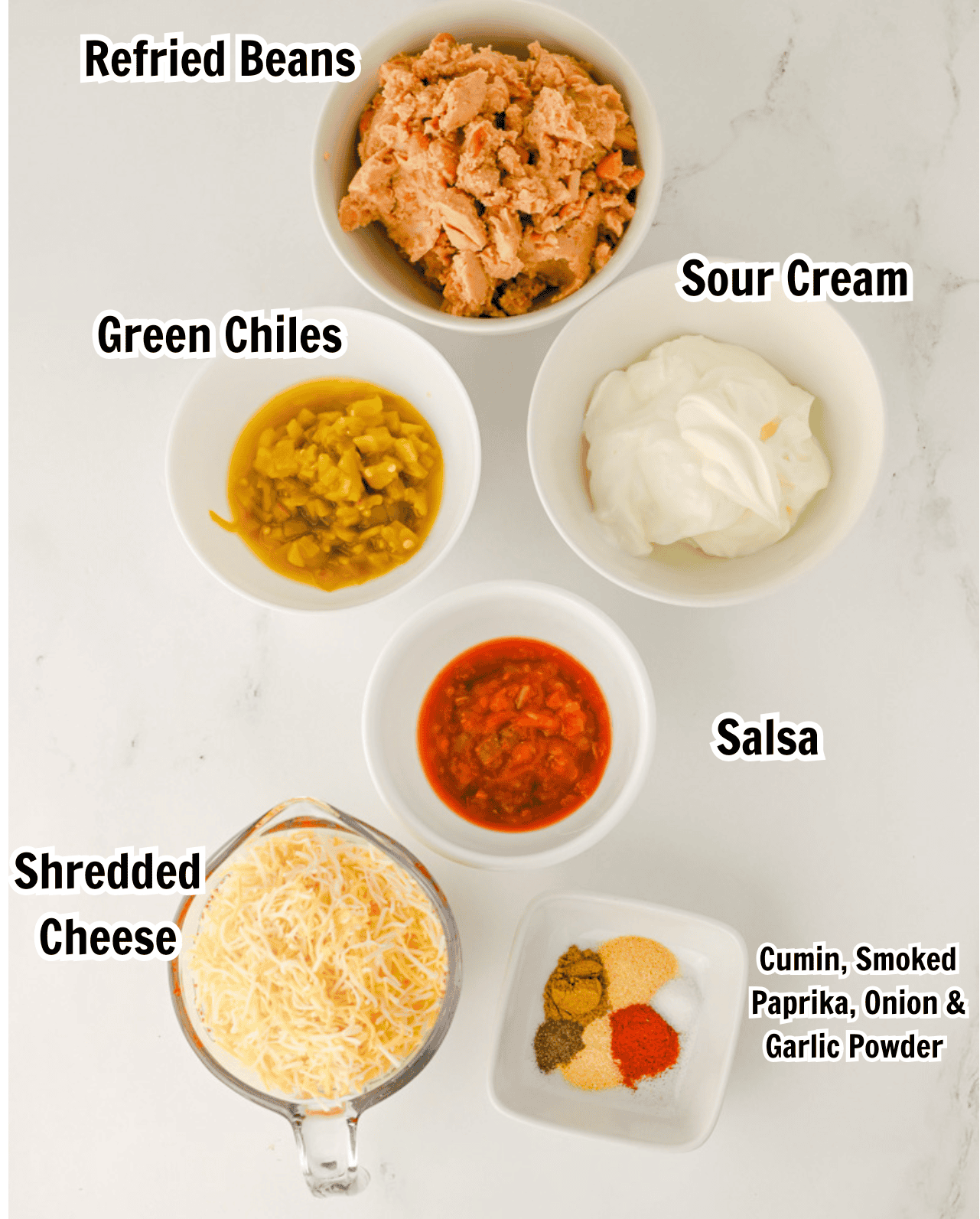 ingredients including refried beans, sour cream, green chiles, sour cream, salsa, shredded cheese, cumin, and paprika.