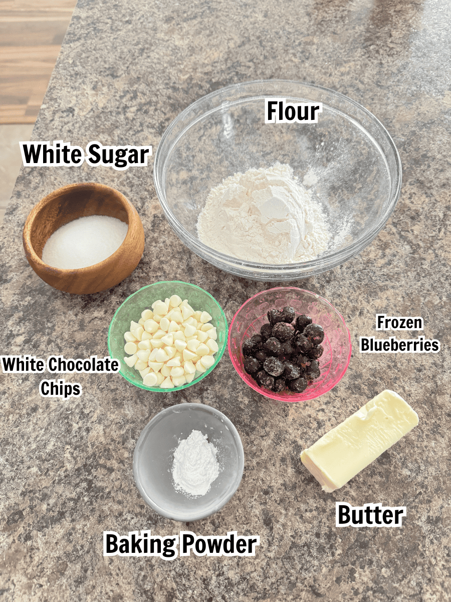 ingredients including flour, sugar, blueberries, butter, white chocolate chips, and baking powder.