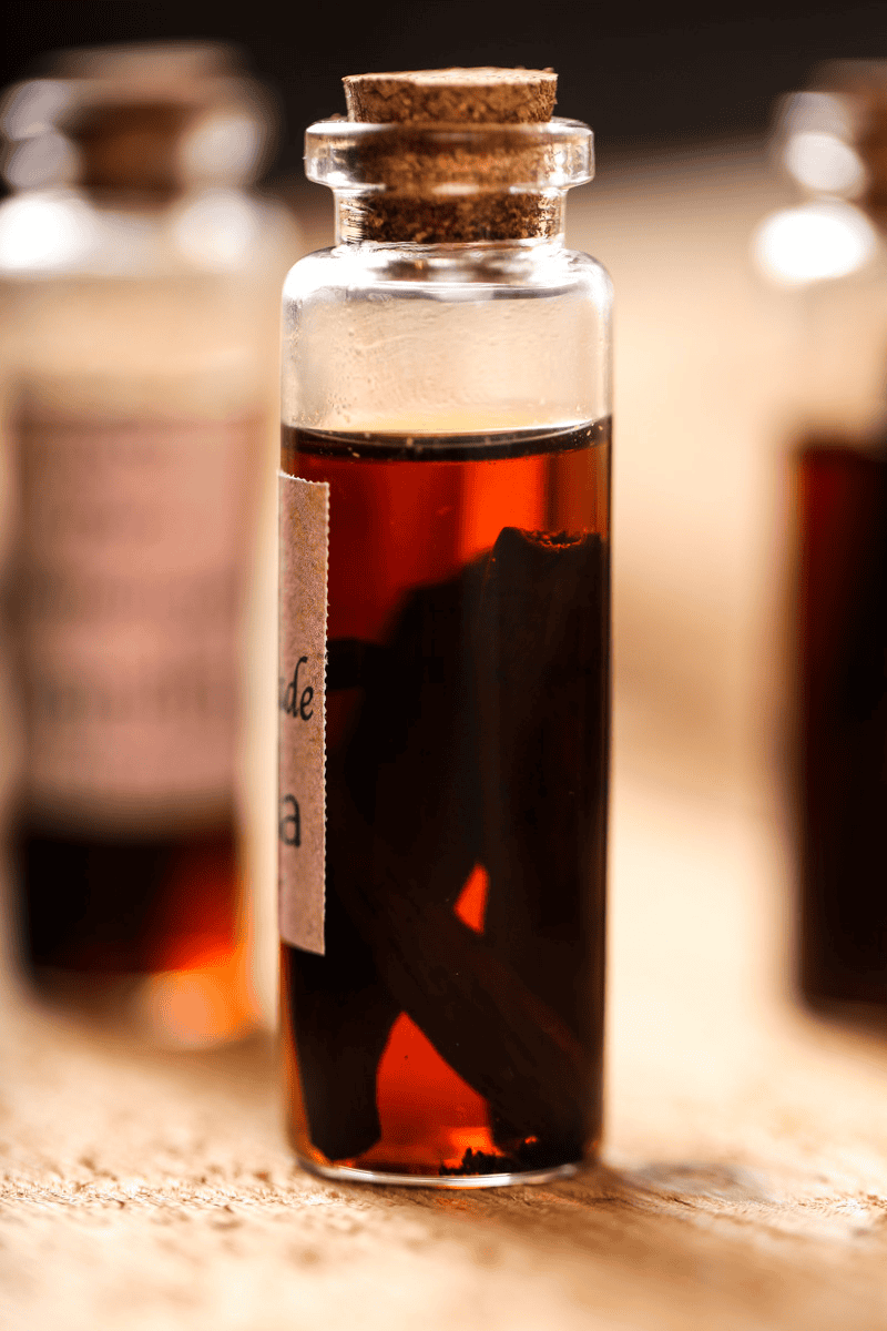 a bottle of homemade vanilla extract with vanilla pods floating inside.