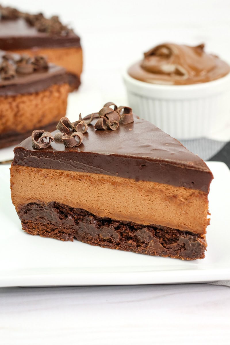 a Nutella mousse cake with a brownie base, Nutella mousse, and Nutella ganache topped with chocolate curls.
