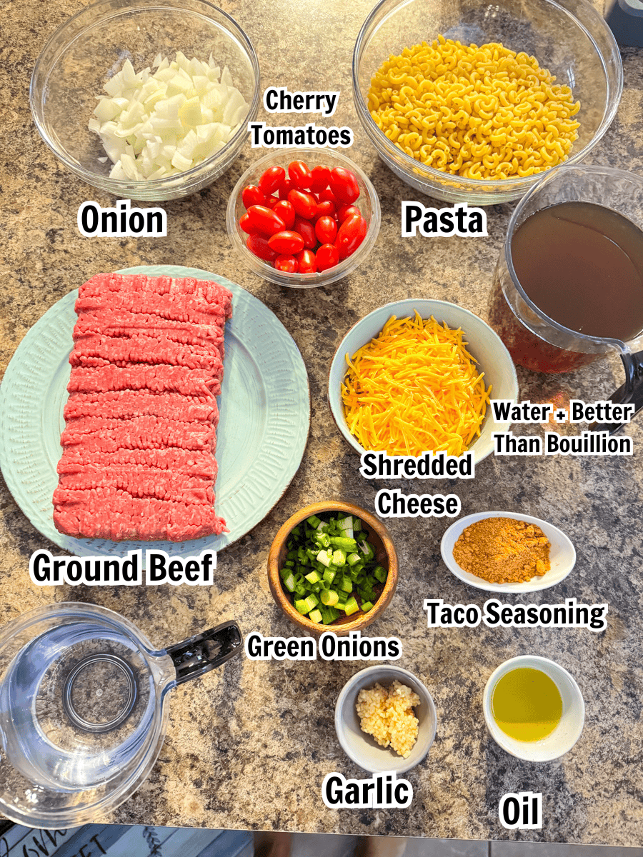 ingredients including elbow noodles, onion, cherry tomatoes, pasta, ground beef, cheese, broth, and taco seasoning.