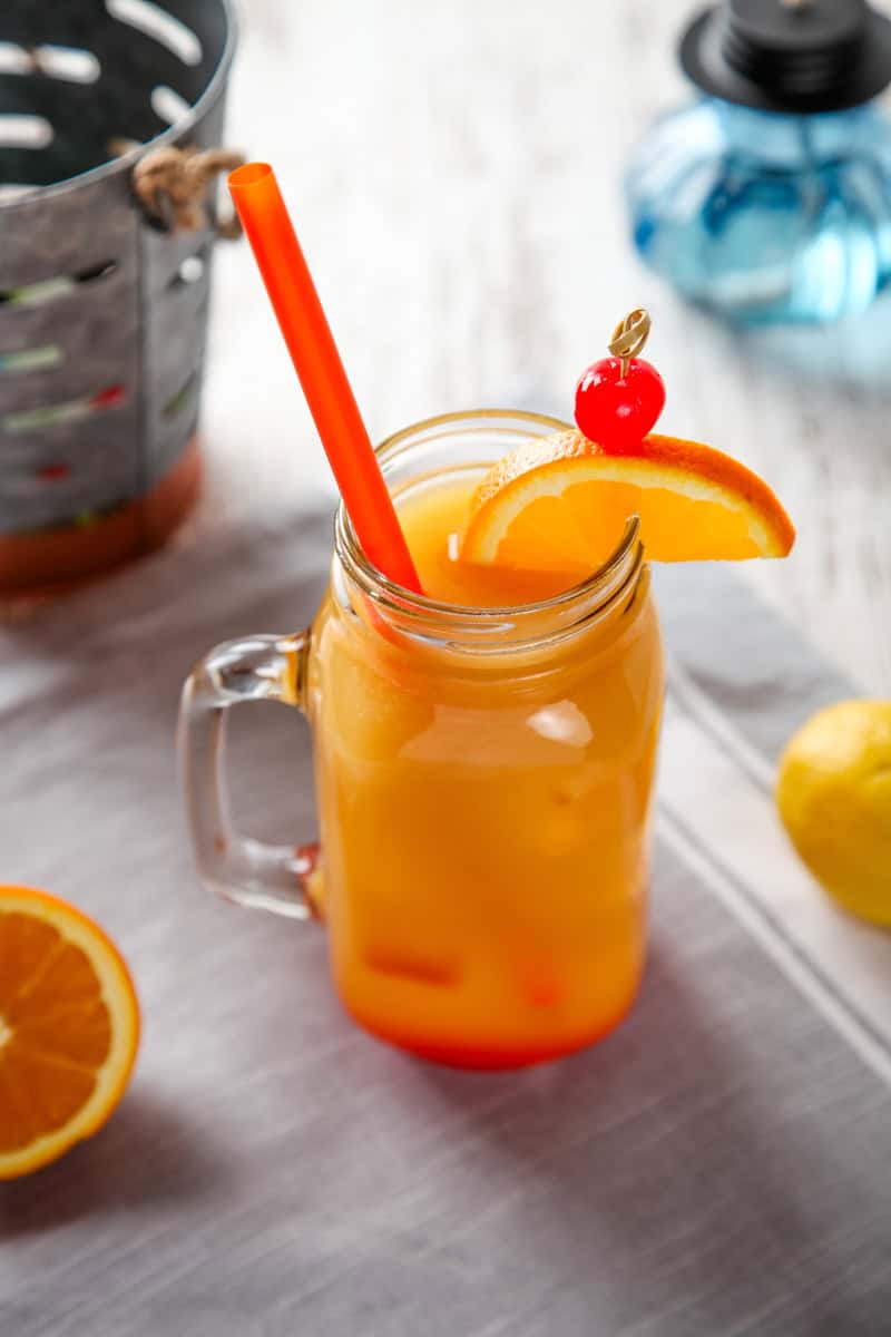 a planters punch drink with an orange slice and cherry garnish.