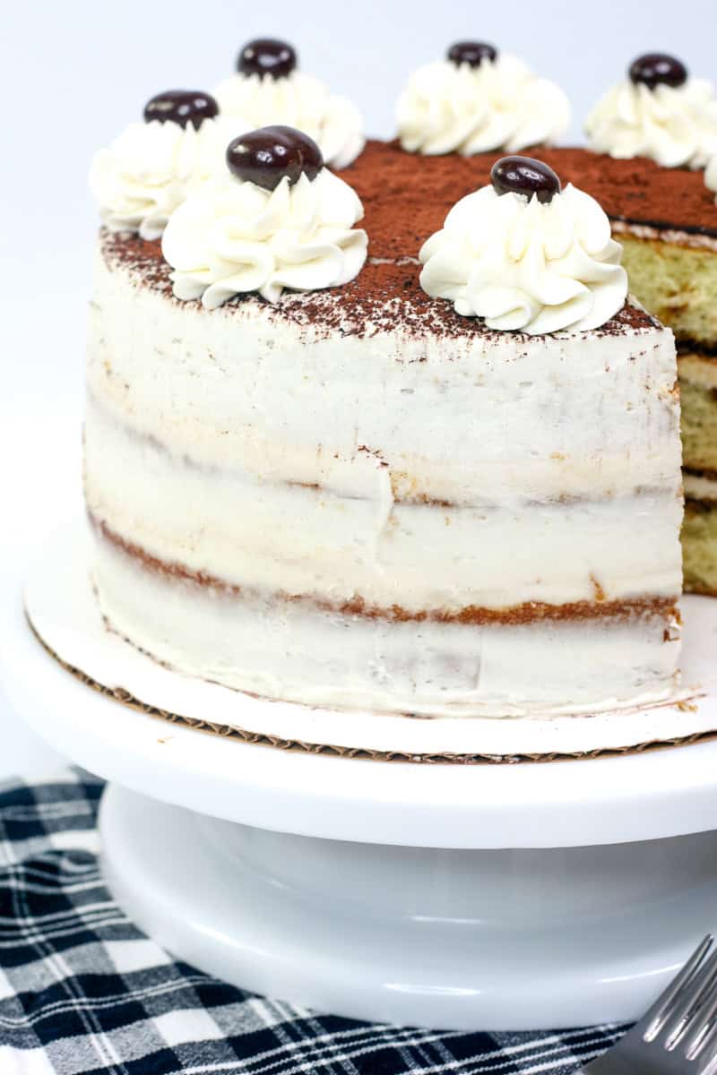 a photo showing a thin crumb coat of frosting on a tiramisu cake.