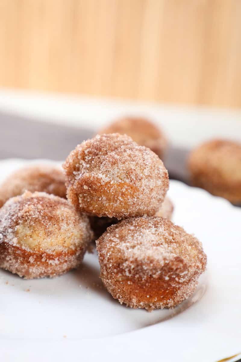 a plate of cinnamon sugar donut mini muffins stacked on top of each other.