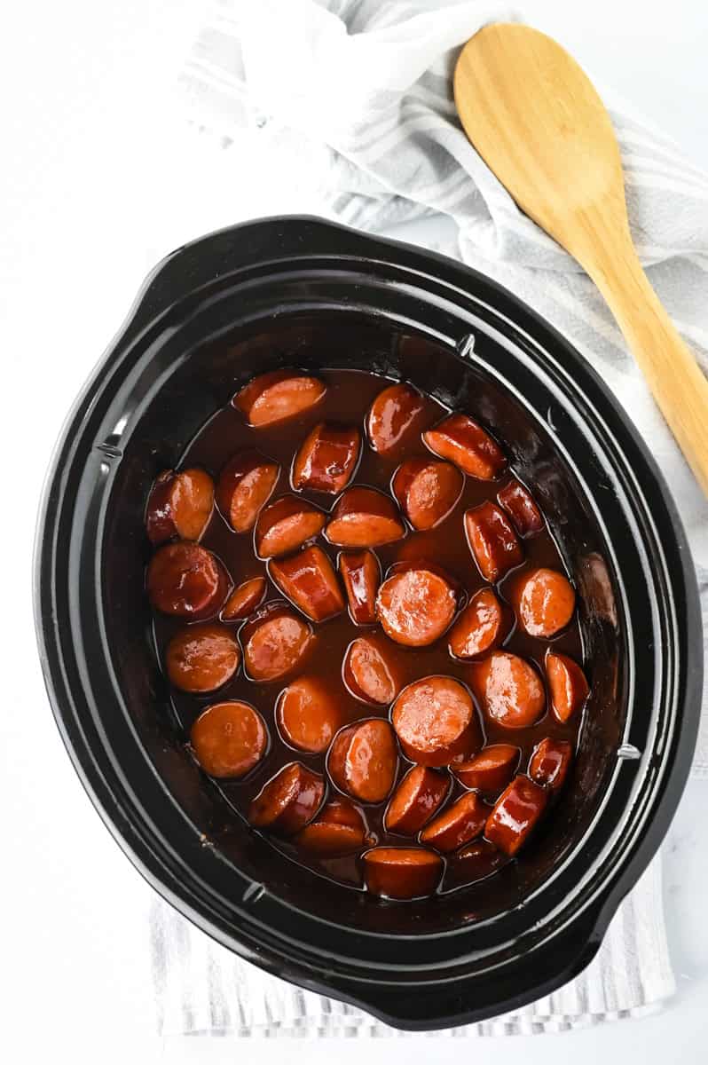 a crock pot full of bbq kielbasa bites. 
