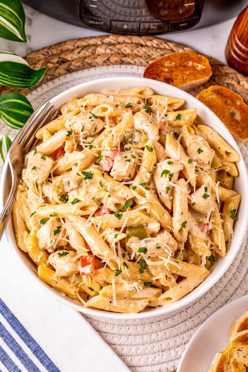 a plate of crock pot Cajun pasta with chicken topped with Parmesan cheese and parsley.