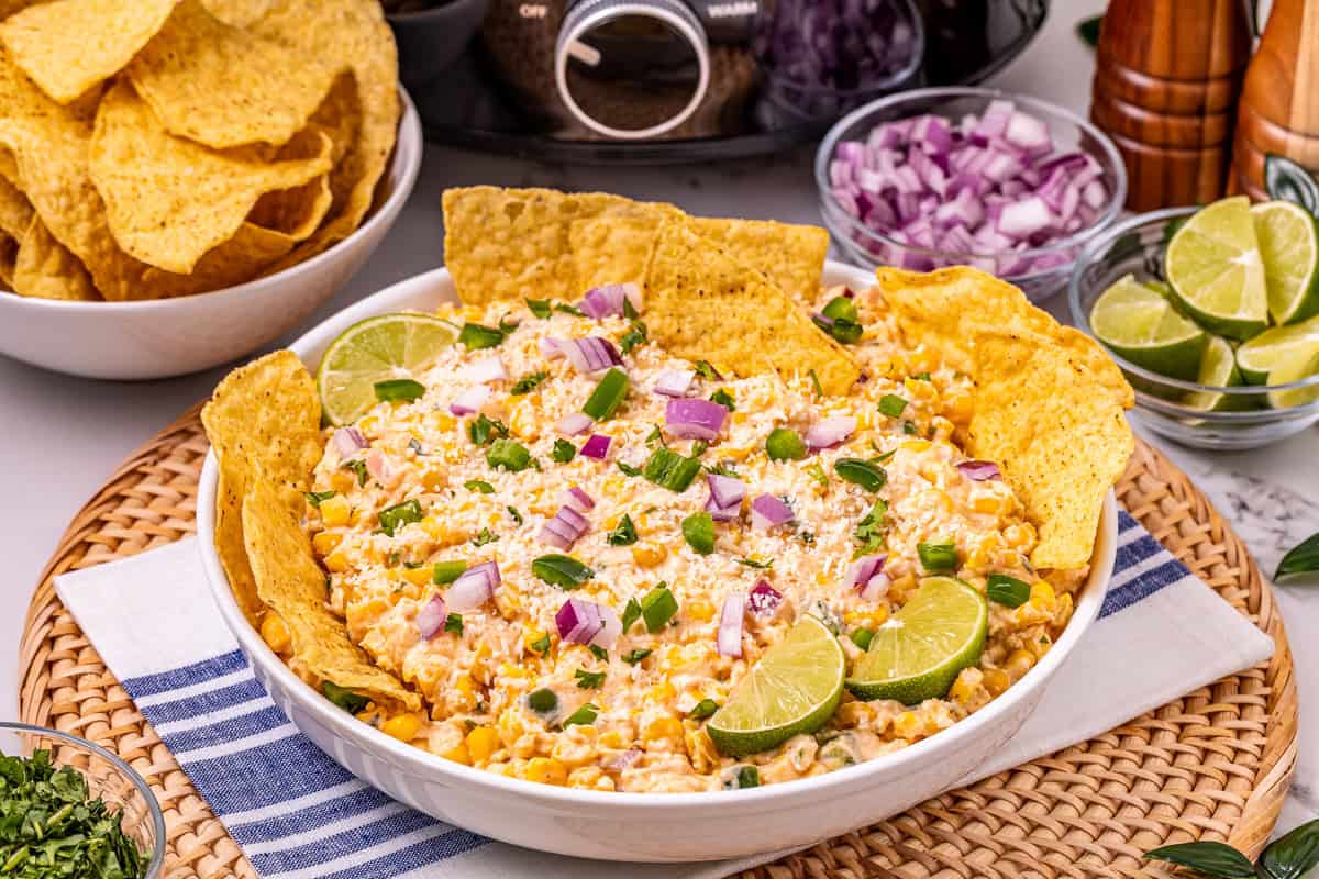 Mexican street corn dip in a bowl with tortilla chips.