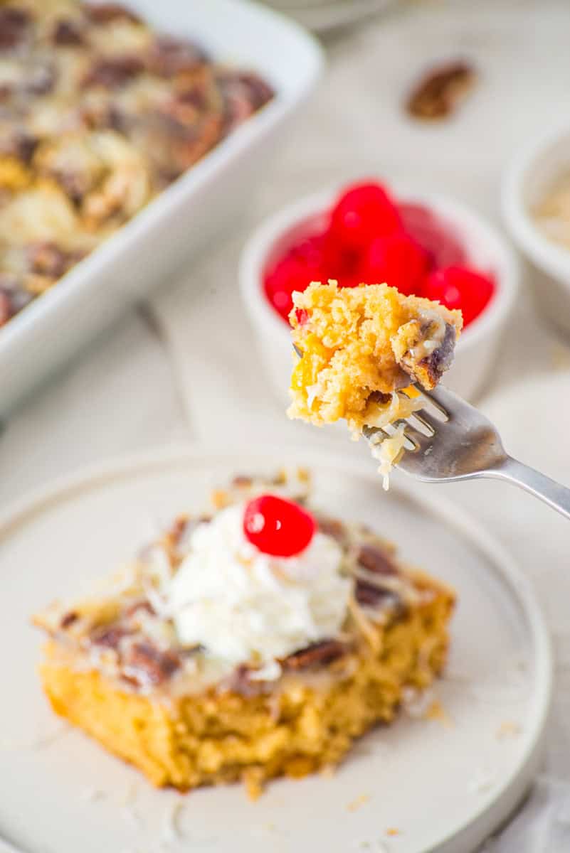 a closeup of a bite of fruit cocktail cake on a fork.
