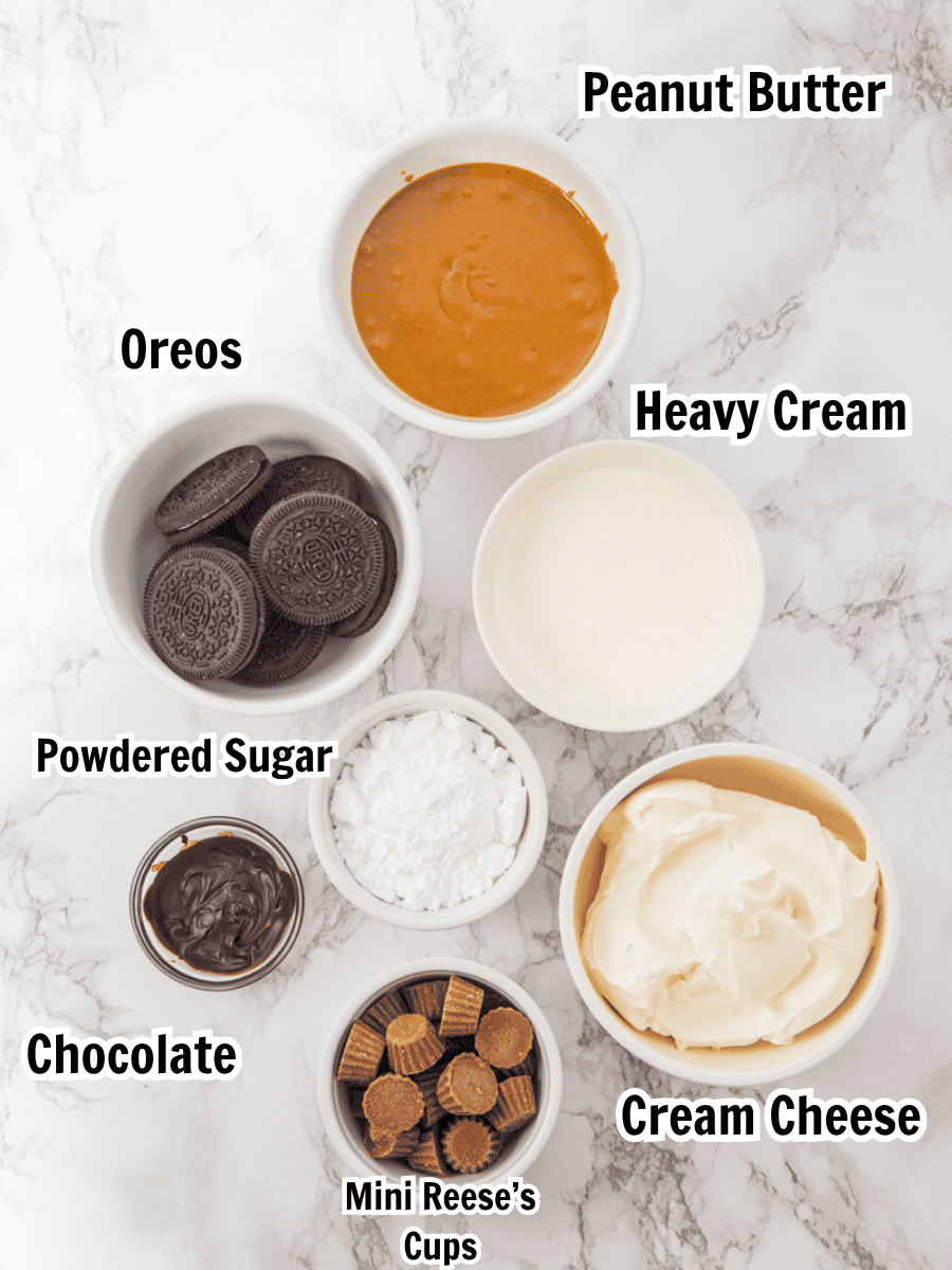 ingredients including peanut butter, oreos, heavy cream, powdered sugar, cream cheese, chocolate, and Reese's cups.