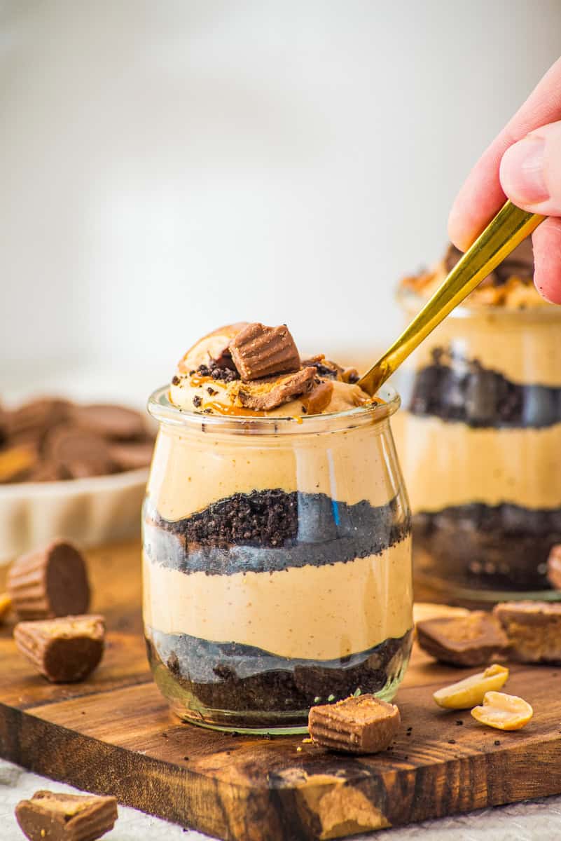 a spoon digging ito a jar or Oreo crumbs and peanut butter mousse. 