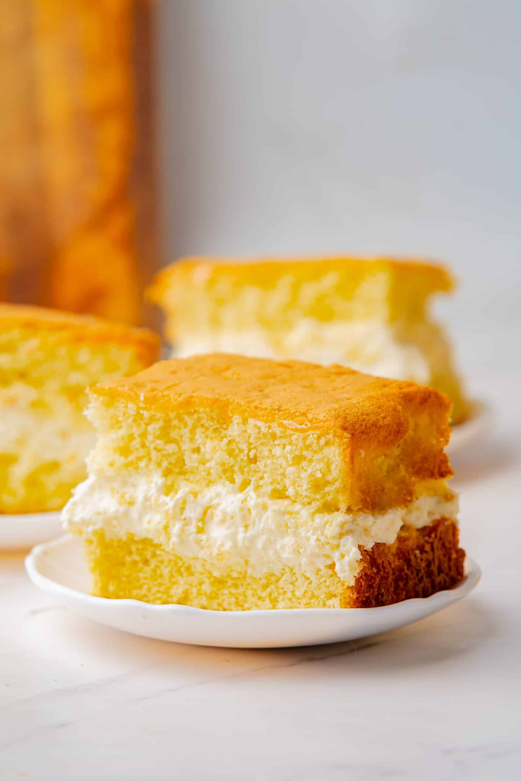 a homemade twinkie cake with cream filling on a white plate.