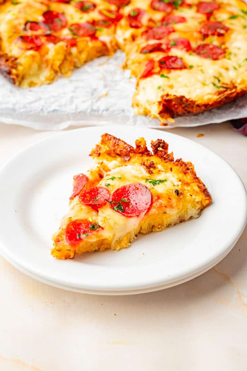 a slice of cast iron pepperoni pizza on a white plate.