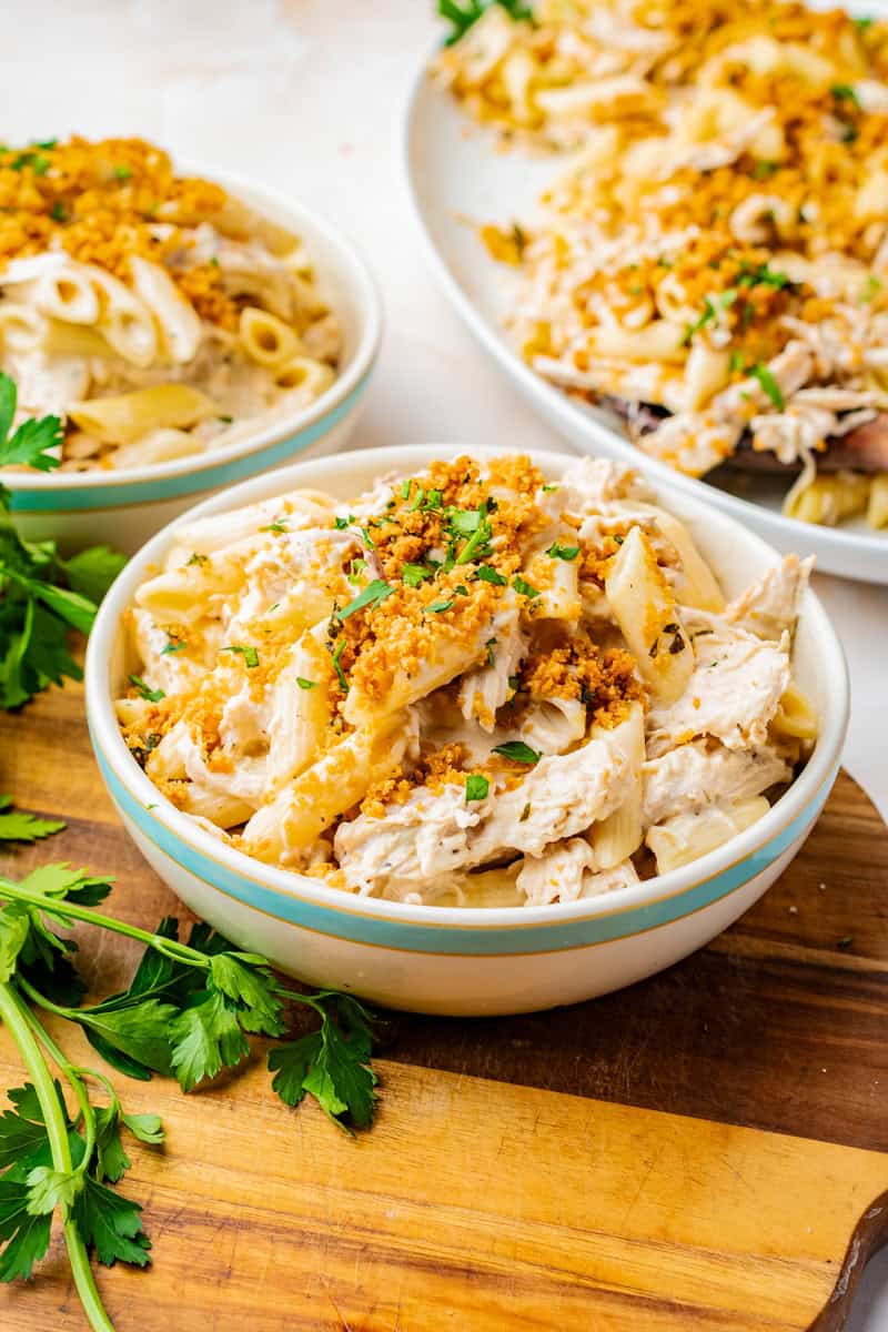a bowl of pasta with chicken, olive garden dressing, a creamy sauce and bread crumb topping.