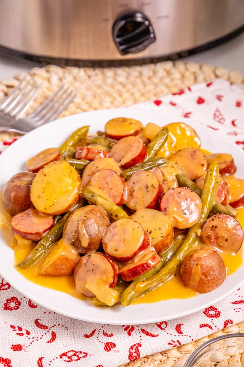 a plate of swamp potatoes with sausage and fresh green beans in a creamy Cajun sauce.