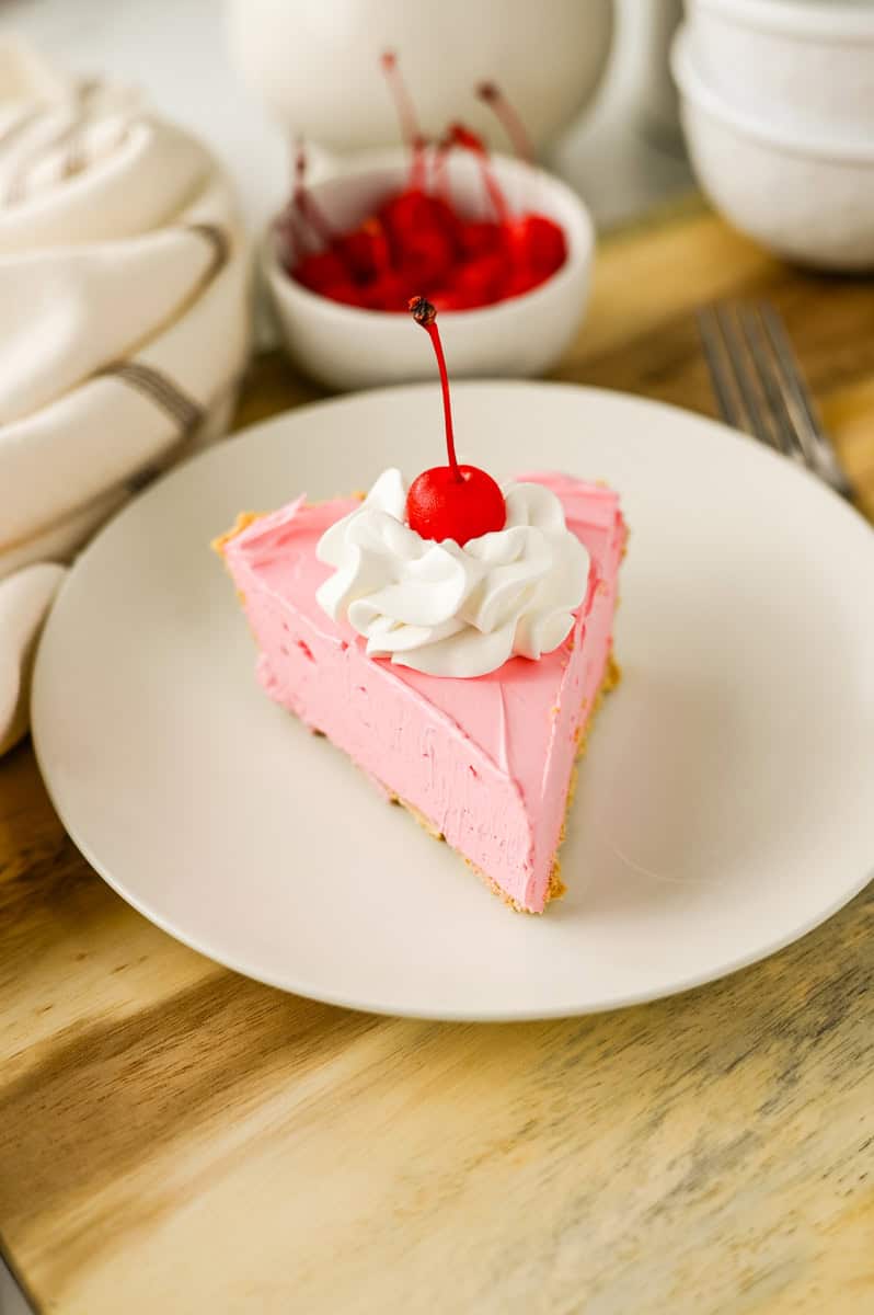 a slice of pink Cool Whip pie in a graham cracker crust.
