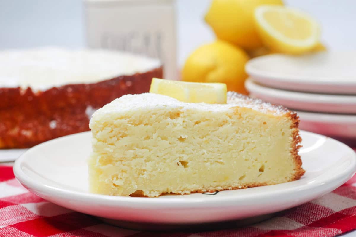 a closeup of a slice of lemon cake with ricotta on a white plate.