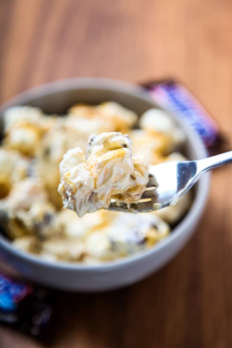 a forkful of snickers salad with caramel, apples, and marshmallows.