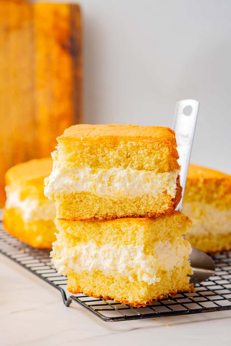 two slices of twinkie cake with flour frosting on top of each other.